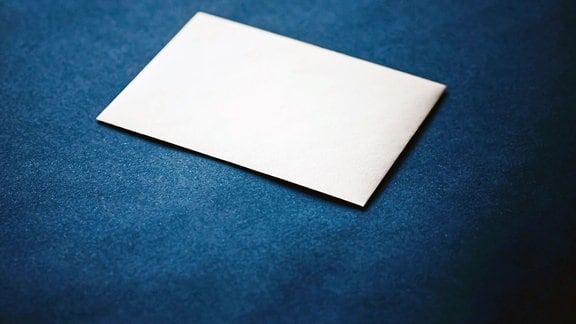 Briefumschlag weiß vor blauem Hintergrund.