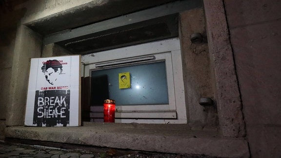 Vor dem Eingang zum Polizeirevier in der Wolfgangstrasse steht ein Foto von Oury Jalloh und eine Trauerkerze an einem Kellerfenster