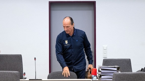 Reichsbürger-Aktivist Peter Fitzek bereitet sich in einem Saal des Landgerichts Dessau auf den Beginn der Verhandlung vor.
