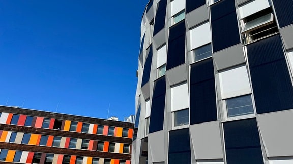Ein modernes schwarz-weißes geometrisch gestaltetes Gebäude und ein in Rottönen gestaltetes modernes gebäude
