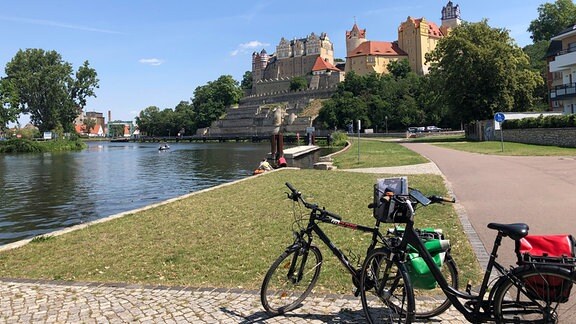 Fahrräder auf dem Saale-Radweg vor dem Schloss Bernburg über der Saale.
