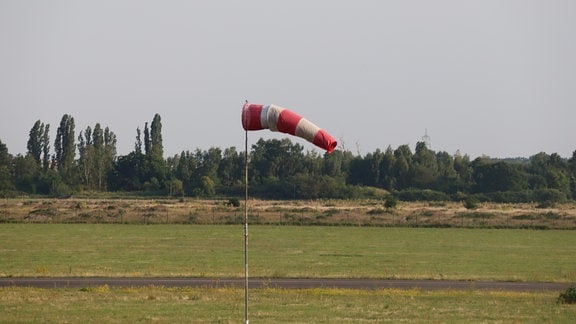 Ein Windsack zeigt auf einem Flugplatz mäßig kräftigen Wind an