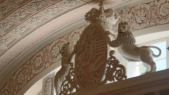 Im Schloss Köthen hängt das Wappen von Anhalt unterhalb der Decke im Spiegelsaal