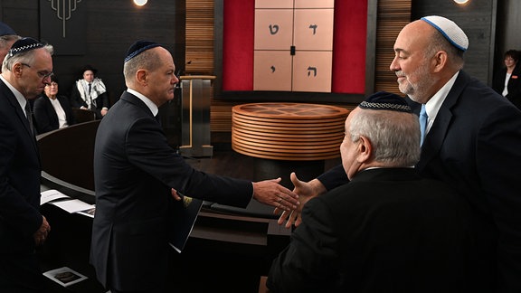 Olaf Scholz gibt Ron Prosor bei der Einweihung der neu erbauten Synagoge in Dessau-Roßlau die Hand.