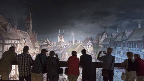 Besucher*innen des Asisi Panometer Wittenberg betrachten einen Ausschnitt des Gemäldes.