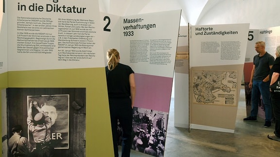 Frauen und Männer stehen im Schloss Colditz in der Wanderausstellung "Auftakt des Terrors- Frühe Konzentrationslager im Nationalsozialismus".