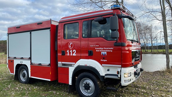 Ein Feuerwehrauto steht auf einer Wiese.