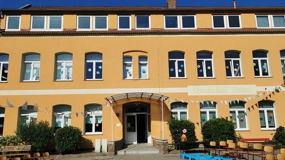 Das orangene Gebäude einer frischsanierten Grundschule