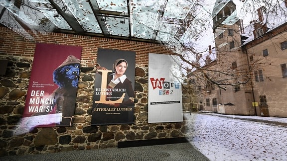 In einer Scheibe des Augusteums mit der Ausstellung "Buchstäblich Luther" spiegelt sich das Lutherhaus.