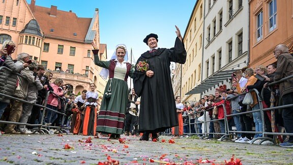 Das Brautpaar Martin Luther und Katharina von Bora, dargestellt von Carolin und Oliver Koschmieder winken den Zuschauern am Rand des Festumzuges.