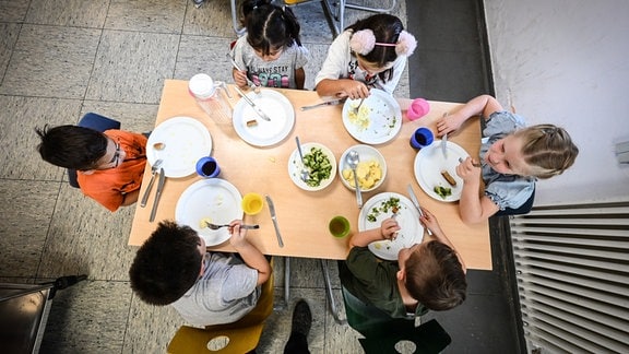 Kinder beim Essen in der Mensa in der Grundschule