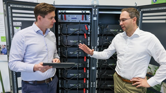 Die Tesvolt Gründer und Geschäftsführer Simon Schandert (l) und Daniel Hannemann stehen vor einem Batteriespeicher in ihrem Unternehmen.