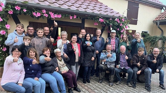 Eine Gruppe Menschen zeigt den Daumen hoch