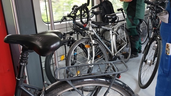 Ein Bahnwaggon steht vollgestellt mit Fahrrädern.