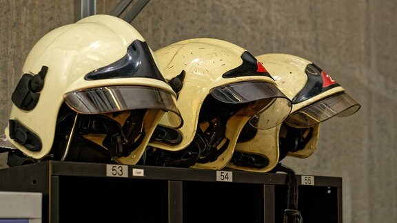 Helme liegen auf einem Schrank bereit.
