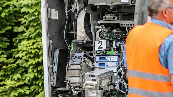 Polizist untersucht einen gesprengten Fahrkartenautomaten der Bahn.