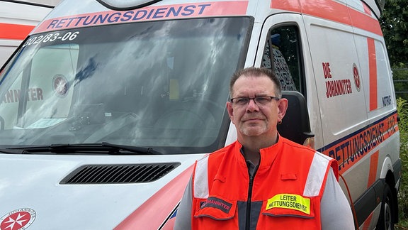 Der Leiter der Rettungswache Naumburg, Sven Siebert, steht vor einem Rettungswagen. 