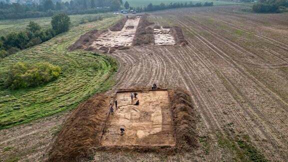 Grabungsteilnehmer legen die Reste eines Burgfriedes auf dem Gelände der Königspfalz Helfta frei.