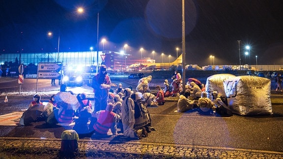 Aktivisten der Initiative CancelLEJ blockieren 2021 eine LKW Zufahrt des DHL-Terminals am Flughafen Leipzig/Halle.