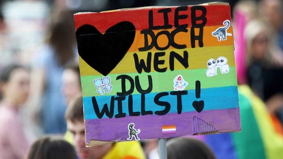 "Lieb doch wen du willst" steht auf einem Plakat, was von Teilnehmern eines CSD hochgelalten wird