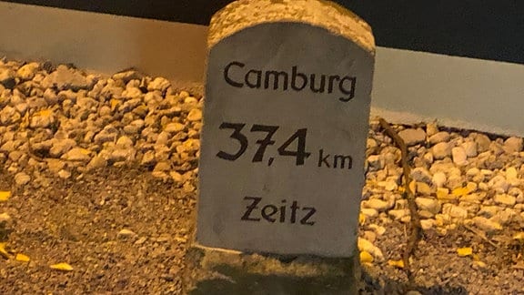 Ein Stein am Wegesrand zeigt an: "Camburg 37,4 km Zeitz"