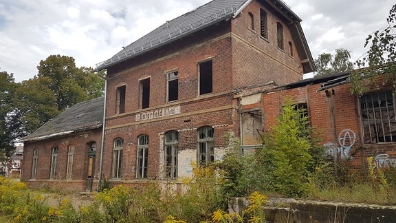 Ein zerfallenes Bahnhofsgebäude ohne Fensterscheiben