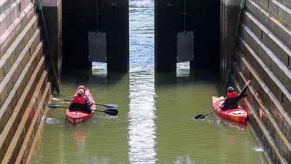 Kanufahrer warten in einer Schleuse auf der Unstrut