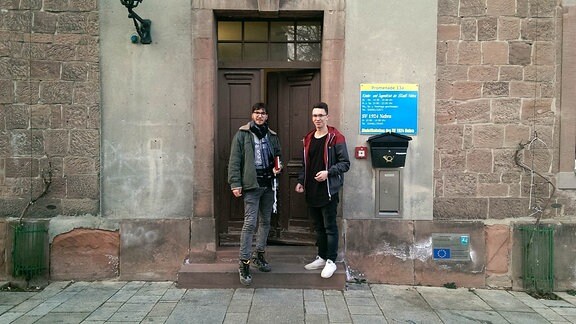 Zwei Menschen stehen vor einer Tür