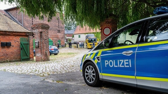 Ein Polizeiauto steht vor dem Rittergut des früheren AfD-Vorsitzenden von Sachsen-Anhalt, Poggenburg.