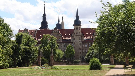 Blick durch den grünen Schlosspark von Merseburg auf das Schloss