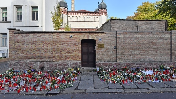 Blumen und Kerzen stehen neben der Tür zur Synagoge, vier Tage nach dem rechtsextremistischen Anschlag auf die Gemeinde