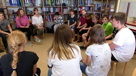 Schüler sitzen in einem Kreis