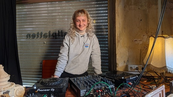 Lucie Lehmann steht am DJ Pult