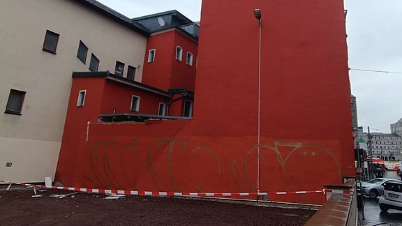 rot gestrichene Wand einer Gebäuderückseite mit einem Spalt an einer Kante