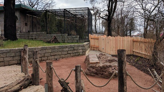 Eine begehbare Außenanalge in einem Zoo mit einer Sitzbank in der Mitte.