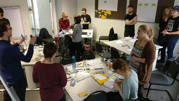 Studenten des Studiengangs Multimedia und Autorschaft stehen in einem Seminarraum der Martin-Luther-Universität in Halle.