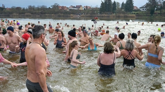 Die Teilnehmer des traditionellen Neujahrsschwimmen stürmen nach dem Startschuss in den Heidesee. Bei fünf Grad Wassertemperatur trauten sich 243 Menschen ins Wasser. 