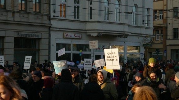 Menschen bei einer Demo in Halle, es sind mehrere Schilder der Gruppe "Omas gegen Rechts" zu sehen