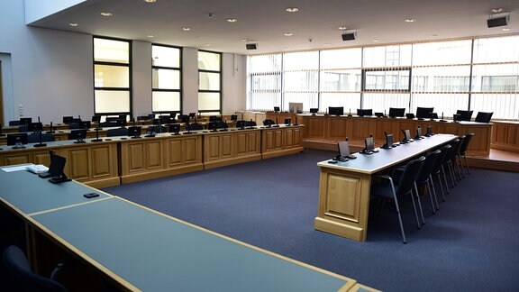Blick auf mit hellem Holz vertäfelten Zeugenstand, Anklagebank und Nebenklage im größten Gerichtssaal Sachsen-Anhalts. 