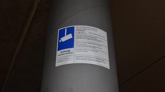 Ein Schild an einer Säule am Riebeckplatz in Halle zeigt, dass dort Videoüberwachung stattfindet