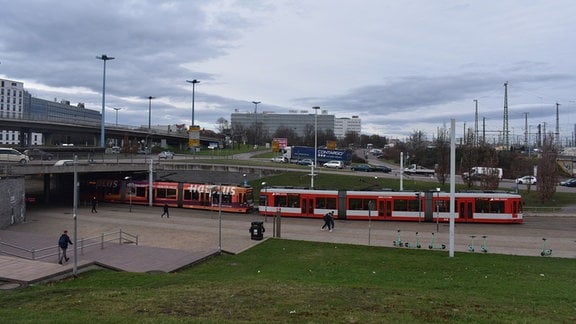 Blick von einer Anhöhe auf den Riebeckplatz in Halle, wo eine Straßenbahn lang fährt.