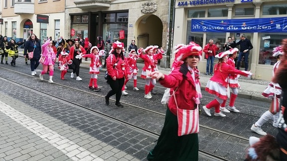 Karnevalisten ziehen durch eine kleinere Straße in Halle 