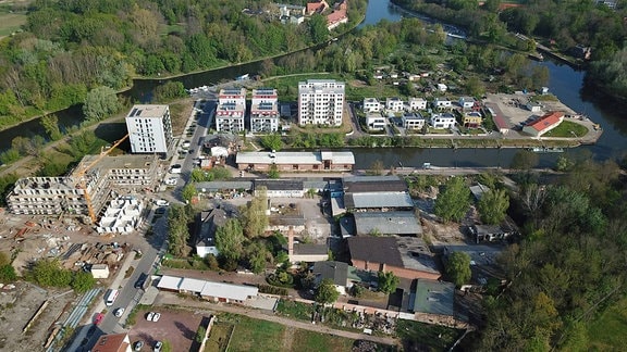Luftaufnahme aus Halle mit mehreren Gebäuden auf einem Areal zwischen zwei Flussarmen