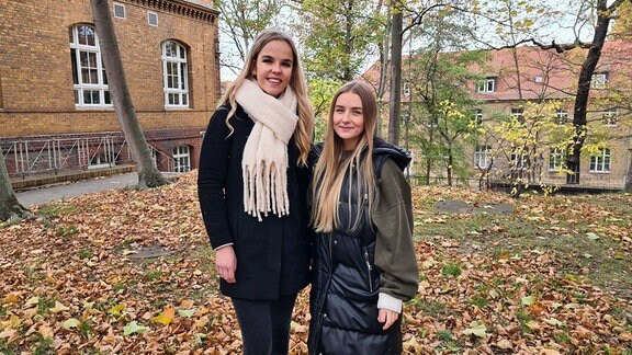 Zwei junge Frauen mit dicken Jacken an einem Herbsttag.