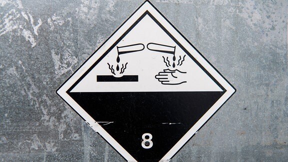 Gefahrgut, Aufkleber mit Hinweis auf die Gefahrgutklasse 8 - Ätzende Stoffe - auf einem Transportbehälter.