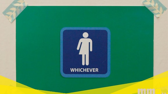 Ein Schild mit der Aufschrift "whichever" an einer Toilettentür
