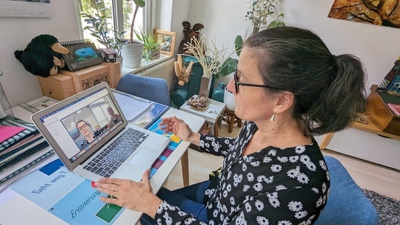 Frau in einer Online-Konferenz am Laptop