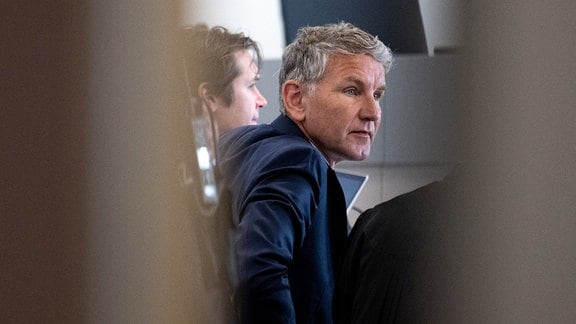 Björn Höcke, Vorsitzender der Thüringer AfD, ist in einer Verhandlungspause durch die geöffnete Tür des Gerichtssaals im Landgericht zu sehen.