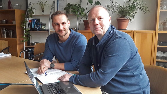 Zwei Männer, Stephan Dammköhler (links) und Florian Brode, sitzen an einem Laptop