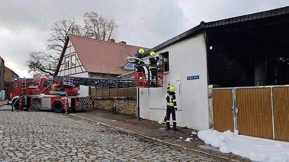 Feuerwehrleute spritzen Löschschaum in eine Fleischerei in Ummendorf.